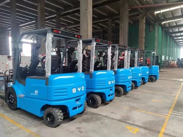 BYD electric forklift fleet inside a glass factory